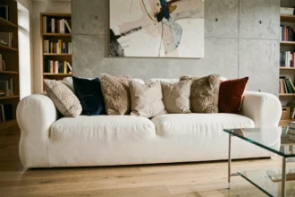 Canapé nuage blanc surchargé de coussins dépareillés dans un salon moderne mal agencé, erreurs de décoration à éviter
