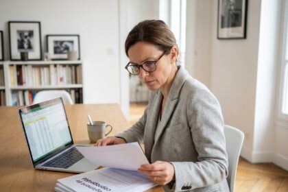 Femme copropriétaire consultant son règlement de copropriété et ses charges à son domicile