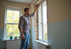 Ajouter une fenêtre sans permis de construire : ce que dit la réglementation Homme mesurant une nouvelle fenetre dans une maison